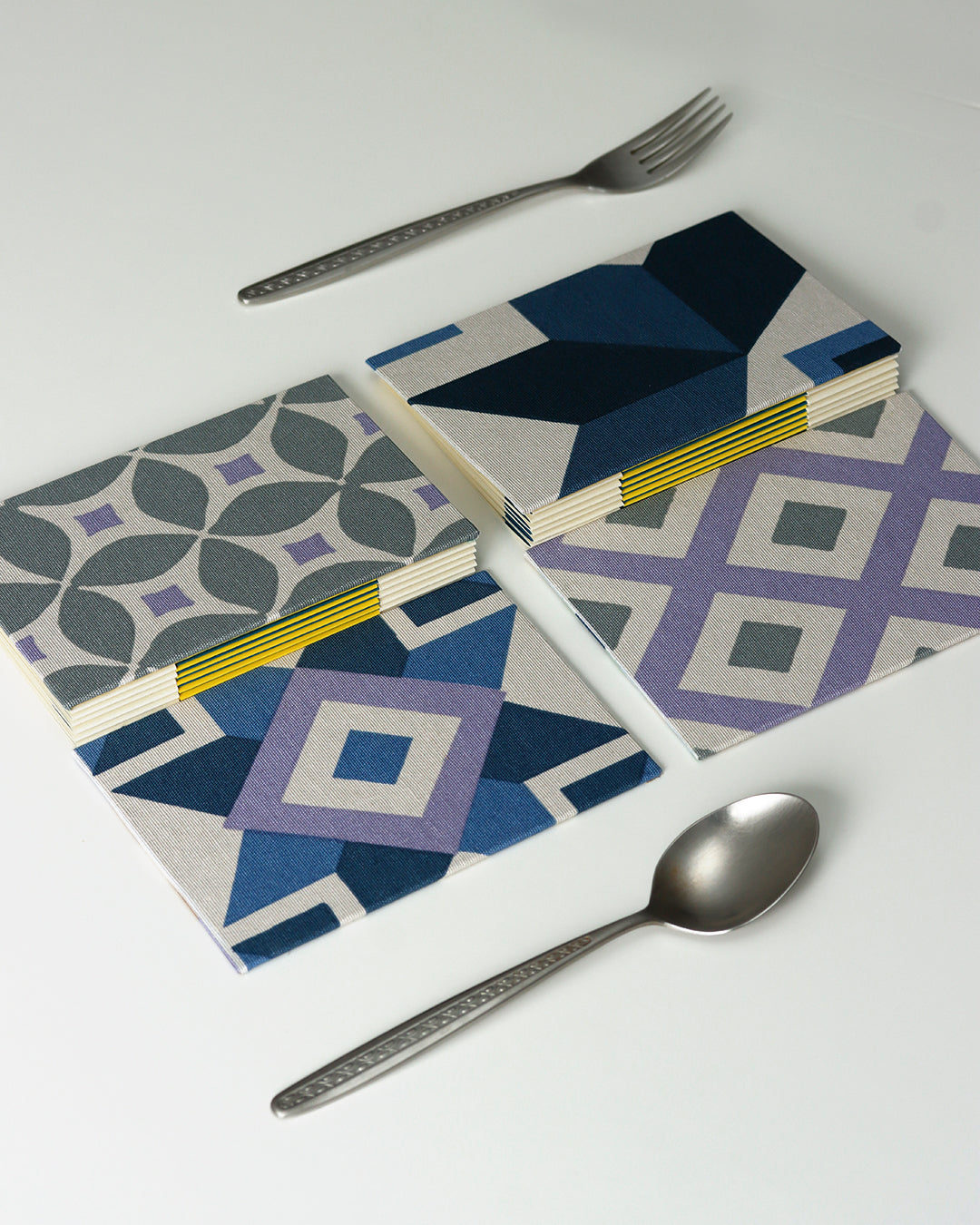 Ricettario formato A6, carta agrumi, rilegatura australiana, piastrelle colorate grigio, lilla e blu (rombi)