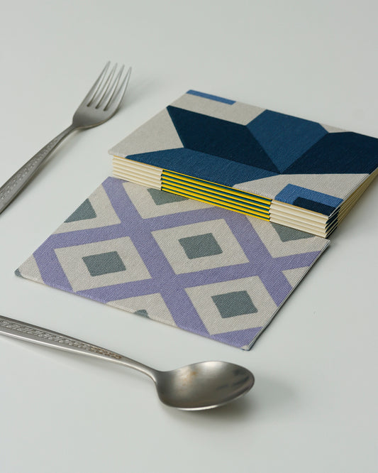 Ricettario formato A6, carta agrumi, rilegatura australiana, piastrelle colorate grigio, lilla e blu (rombi)