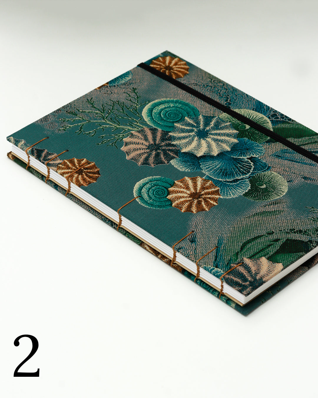 Quaderno per calligrafia con rilegatura copta, copertina in tessuto stampato con conchiglie e ricci di mare stile tavola naturalistica ottocentesca su fondo verde petrolio, elastico e filo golden brown