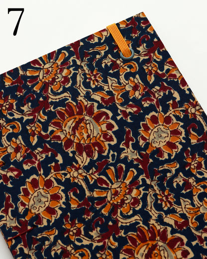Quaderno per calligrafia con rilegatura copta, copertina in tessuto floreale block-print blu notte con motivi arancio, bordeaux e oro, elastico arancio, filo bordeaux