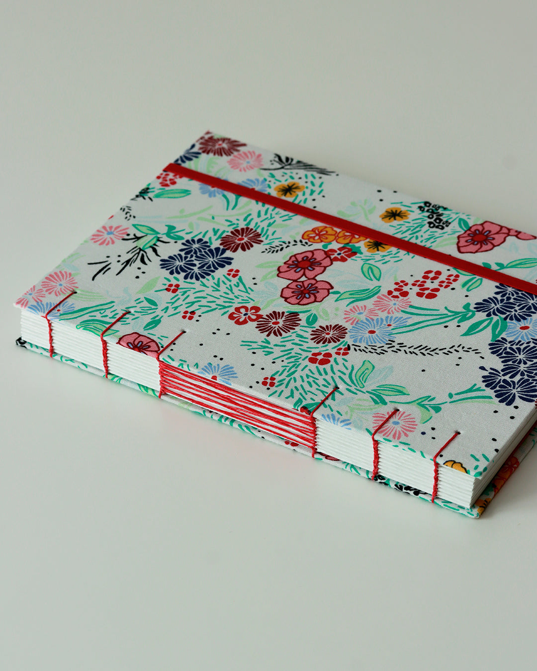 Agenda 2026 fiorellini colorati su bianco (mix copta-francese con elastico e busta)