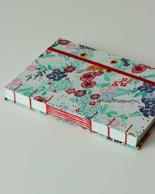 Agenda 2026 fiorellini colorati su bianco (mix copta-francese con elastico e busta)