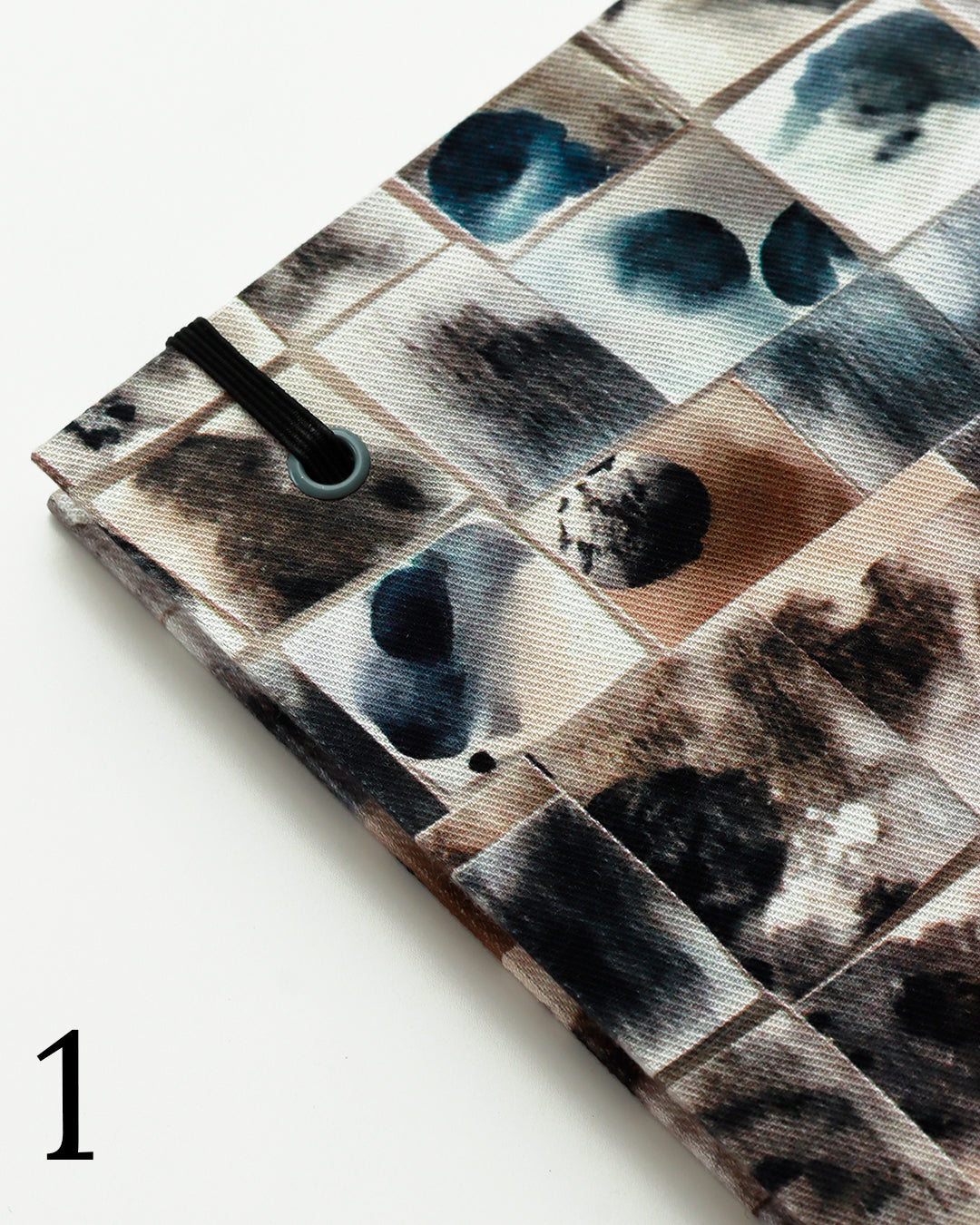 Quaderno per calligrafia con rilegatura copta, copertina in tessuto a griglia patchwork con macchie d'inchiostro blu, nero, marrone e crema, elastico nero, filo marrone